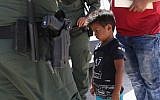 A boy from Honduras is shown being taken into custody by US Border Patrol agents near the US-Mexico Border near Mission, Texas, on June 12, 2018. (John Moore/Getty Images via JTA)