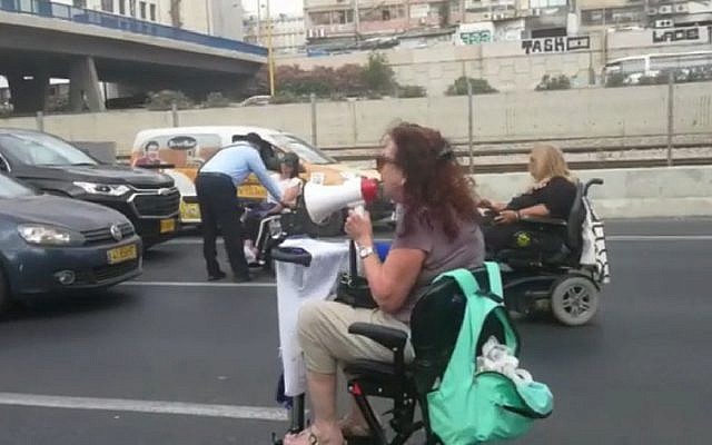 A handful of wheelchair-bound protesters close Tel Aviv's Ayalon Highway for an hour on June 28, 2018. (Screen capture: Hadashot news) A handful of wheelchair-bound protesters close Tel Aviv's Ayalon Highway for an hour on June 28, 2018. (Screen capture: Hadashot news)