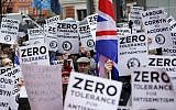 Illustrative: People hold up placards and Union flags as they gather for a demonstration organized by the Campaign Against Anti-Semitism outside the head office of the British opposition Labour Party in central London on April 8, 2018. (AFP/Tolga Akmen)