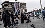Pedestrians walk past a poster of Turkish President Recep Tayyip Erdogan under the caption, 'Thank you Istanbul,' at Taksim Square in Istanbul, on June 28, 2018. (AFP Photo/ Bulent Kilic)