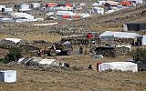 A picture taken on June 30, 2018, from the Israeli Golan Heights shows a tractor-led trailer carrying civilians arriving at a camp for displaced Syrians near the Syrian village of Burayqah in the southern province of Quneitra, just across the border from Israel. (AFP Photo/Jalaa Marey)