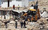 Israeli police secure a bulldozer demolishing structures at the Bedouin village of Abu Nuwar, east of Jerusalem in the West Bank on July 4, 2018. (AHMAD GHARABLI/AFP)