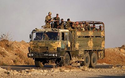 Syrian government soldiers ride in an army truck near the Nassib border crossing with Jordan in the southern province of Daraa on July 6, 2018, after they regained control over it from rebel forces. (AFP PHOTO / Mohamad ABAZEED)