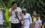 Relatives walk out from the cave complex after taking part in a prayer ceremony as rescue operations continue for the 12 boys and their football team coach trapped in Tham Luang cave in Thailand on July 7, 2018. (AFP PHOTO / YE AUNG THU)