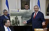Israeli Prime Minister Benjamin Netanyahu receives a gift from the Ze'ev Jabotinsky Institute during the weekly cabinet meeting at his office in Jerusalem, July 8, 2018. (AFP PHOTO / POOL / ABIR SULTAN)