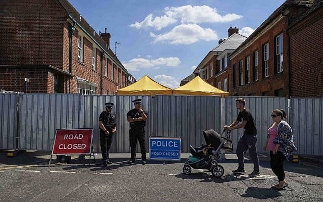 Pedestrians walk past police officers standing guard near barriers across Rollestone Street, outside the John Baker House Sanctuary Supported Living in Salisbury, southern England, on July 8, 2018. (AFP/ NIKLAS HALLE'N) Pedestrians walk past police officers standing guard near barriers across Rollestone Street, outside the John Baker House Sanctuary Supported Living in Salisbury, southern England, on July 8, 2018. (AFP/ NIKLAS HALLE'N)