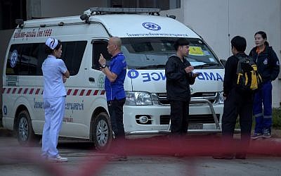 A nurse (L) and rescue personnel stand in front of an ambulance at the hospital where the boys rescued after being trapped in a nearby cave for nearly two weeks have being brought for observation, in the northern Thai city of Chiang Rai on July 9, 2018. (AFP PHOTO / TANG CHHIN Sothy)