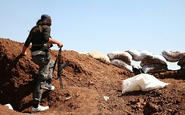 A Syrian rebel carries his machine gun during battles with pro-government fighters in western Daraa province on July 10, 2018. (AFP PHOTO / Ahmad al-Msalam) A Syrian rebel carries his machine gun during battles with pro-government fighters in western Daraa province on July 10, 2018. (AFP PHOTO / Ahmad al-Msalam)