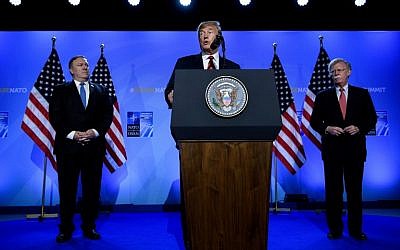 US President Donald Trump (C) is accompanied by US Secretary of State Mike Pompeo (L) and US National Security Adviser John Bolton (R) as he addresses a press conference on the second day of the North Atlantic Treaty Organization (NATO) summit in Brussels on July 12, 2018. (AFP PHOTO / Brendan Smialowski)