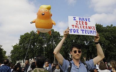 Protesters gather around a giant balloon depicting US President Donald Trump as an orange baby during a demonstration against Trump's visit to the UK in Parliament Square in London on July 13, 2018.(AFP PHOTO / Tolga AKMEN)