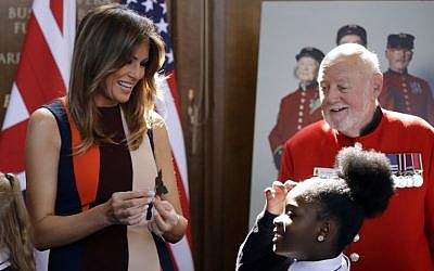 US First Lady Melania Trump (L) helps children make paper flowers as she meets British military veterans known as 'Chelsea Pensioners' during a visit to the Royal Chelsea Hospital in London on July 13, 2018. (AFP Photo/Pool/Luca Bruno)