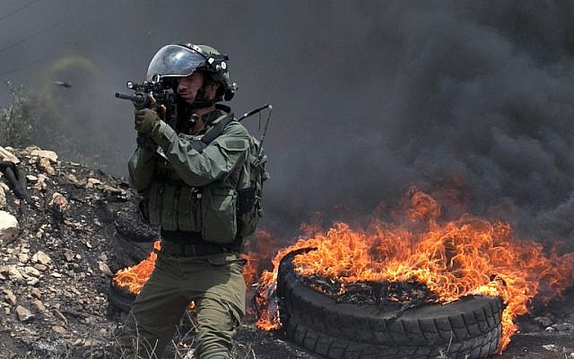 An Israeli soldier fires a rubber bullet towards Palestinian protesters during clashes near Nablus, in the West Bank on July 13, 2018. ( AFP PHOTO / JAAFAR ASHTIYEH) An Israeli soldier fires a rubber bullet towards Palestinian protesters during clashes near Nablus, in the West Bank on July 13, 2018. ( AFP PHOTO / JAAFAR ASHTIYEH)
