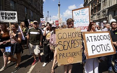 Protesters against the UK visit of US President Donald Trump hold up placards as they take part in a march and rally in London on July 13, 2018. (AFP PHOTO / Niklas HALLE'N)