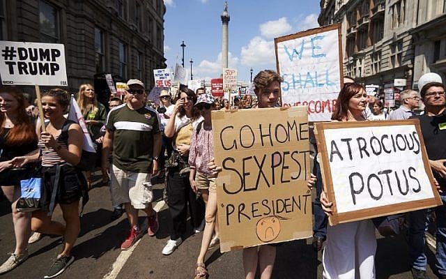 Protesters against the UK visit of US President Donald Trump hold up placards as they take part in a march and rally in London on July 13, 2018. (AFP PHOTO / Niklas HALLE'N)