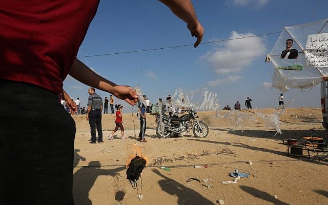 A Palestinian man prepares to attach an incendiary to a kite before flying it towards Israel on July 13, 2018 during a violent protest along the Israel-Gaza border fence east of Gaza City. (AFP PHOTO / MAHMUD HAMS) A Palestinian man prepares to attach an incendiary to a kite before flying it towards Israel on July 13, 2018 during a violent protest along the Israel-Gaza border fence east of Gaza City. (AFP PHOTO / MAHMUD HAMS)