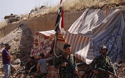 Syrian regime soldiers at a checkpoint watch Syrian rebels during evacuation from Daraa city, on July 15, 2018 (AFP PHOTO/Mohamad ABAZEED)