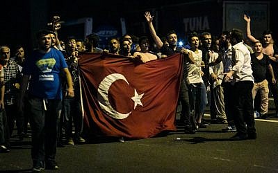 Illustrative photo of people shouting slogans as they carry a flag on a street near the Fatih Sultan Mehmet Bridge during clashes with military forces in Istanbul, July 15, 2016. (GURCAN OZTURK/AFP)