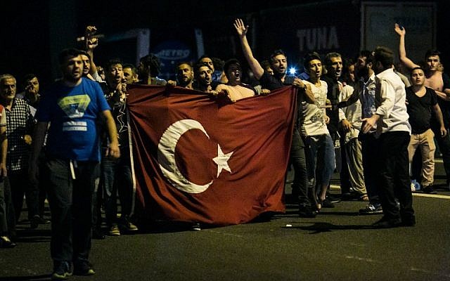 Illustrative photo of people shouting slogans as they carry a flag on a street near the Fatih Sultan Mehmet Bridge during clashes with military forces in Istanbul, July 15, 2016. (GURCAN OZTURK/AFP) Illustrative photo of people shouting slogans as they carry a flag on a street near the Fatih Sultan Mehmet Bridge during clashes with military forces in Istanbul, July 15, 2016. (GURCAN OZTURK/AFP)