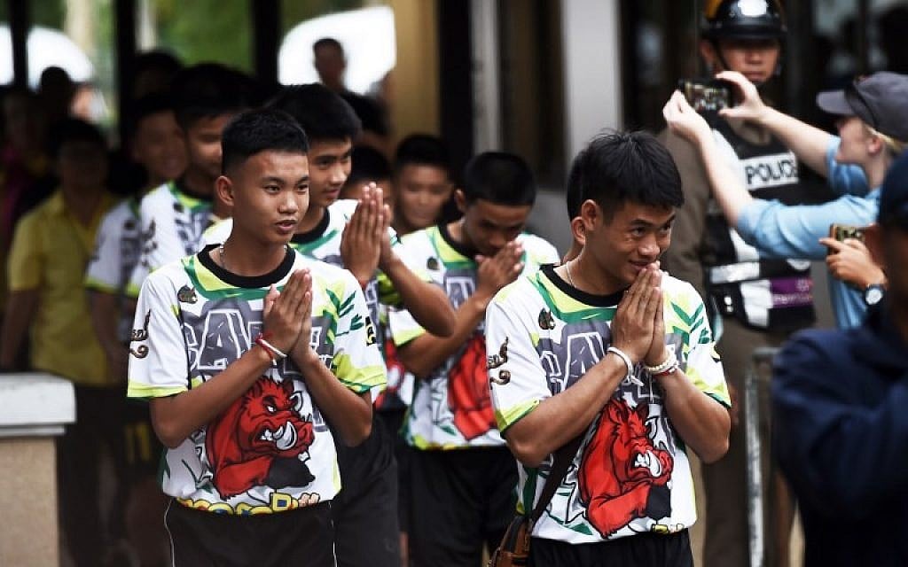 Some of the twelve Thai boys, rescued from a flooded cave after being trapped, arrive to attend a press conference in Chiang Rai on July 18, 2018, following their discharge from the hospital. (AFP PHOTO / Lillian SUWANRUMPHA)