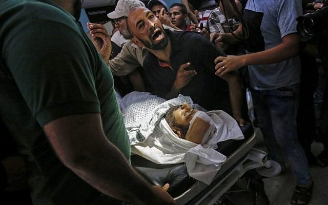 Relatives mourn over the body of Abdel Karim Radwan, a Hamas military winge member who was killed in an Israeli air strike on a group launching fire balloons on July 19, 2018. (AFP PHOTO / SAID KHATIB) Relatives mourn over the body of Abdel Karim Radwan, a Hamas military winge member who was killed in an Israeli air strike on a group launching fire balloons on July 19, 2018. (AFP PHOTO / SAID KHATIB)