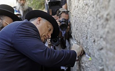 Hungarian Prime Minister Viktor Orban places a paper note at the Western Wall in Jerusalem's Old City during his visit to Israel on July 20, 2018. (AFP PHOTO / MENAHEM KAHANA)