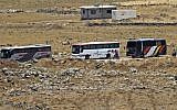 A picture taken on July 20, 2018, from the Israeli Golan Heights shows buses in a southwestern area of Syria that are transferring Syrian rebel fighters and civilians to opposition territory in Idlib further north. (AFP Photo/Jalaa Marey)