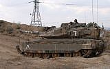 Israeli soldiers ride in the turret of a Merkava battle tank near the Kibbutz of Nahal Oz, along the border with the Gaza Strip on July 20, 2018. (AFP PHOTO / JACK GUEZ)