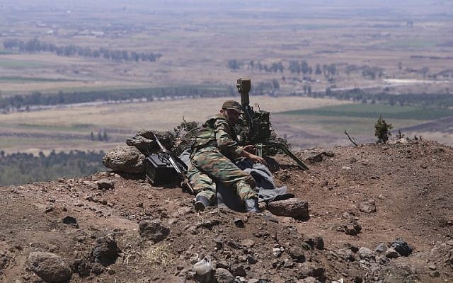 A picture taken on July 22, 2018, during a government guided tour, shows a Syrian regime fighter looking through binoculars from the al-Jabieh hill during their advance on the town of Nawa, in the southern province of Daraa. (AFP / Youssef KARWASHAN)