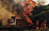 A house is threatened by a huge blaze during a wildfire in Kineta, near Athens, on July 23, 2018. (AFP PHOTO / VALERIE GACHE)