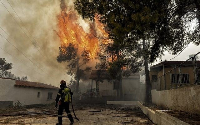 A firefighter tries to extinguish hotspots during a wildfire in Kineta, near Athens, Greece, on July 23, 2018. (VALERIE GACHE/AFP) A firefighter tries to extinguish hotspots during a wildfire in Kineta, near Athens, Greece, on July 23, 2018. (VALERIE GACHE/AFP)