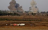 A picture taken on July 24, 2018 from the Tal Saki hill in the Golan Heights shows smoke rising above buildings across the border in Syria during air strikes backing a Syrian-government-led offensive in the southwestern province of Daraa. (AFP/ JALAA MAREY)