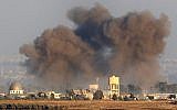 A picture taken on July 26, 2018, near Kibbutz Ein Zivan in the Israeli Golan Heights, shows smoke rising above buildings across the border in Syria during airstrikes backing a government-led offensive in the southern province of Quneitra. (AFP Photo/Jack Guez)