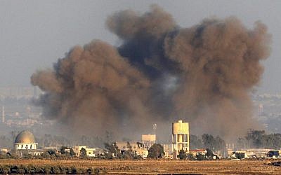 A picture taken on July 26, 2018, near Kibbutz Ein Zivan in the Israeli Golan Heights, shows smoke rising above buildings across the border in Syria during airstrikes backing a government-led offensive in the southern province of Quneitra. (AFP Photo/Jack Guez)