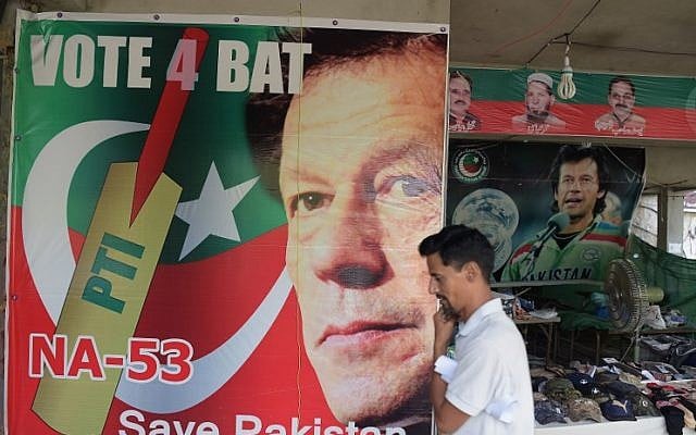 A man walks past a poster of Pakistan's cricketer-turned politician Imran Khan, and head of the Pakistan Tehreek-e-Insaf (Movement for Justice) party, at a market in Islamabad on July 27, 2018. (AFP/Aamir Qureshi) A man walks past a poster of Pakistan's cricketer-turned politician Imran Khan, and head of the Pakistan Tehreek-e-Insaf (Movement for Justice) party, at a market in Islamabad on July 27, 2018. (AFP/Aamir Qureshi)
