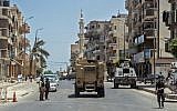 Illustrative: Egyptian policemen driving on a road leading to the North Sinai provincial capital of El-Arish, July 26, 2018. (AFP/Khaled DESOUKI)