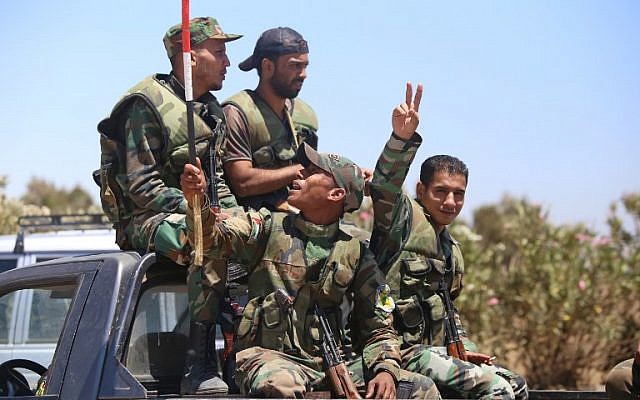 A Syrian soldier gestures as he rides in a car in the town of Quneitra in the Syrian Golan Heights on July 27, 2018. (AFP/Youssef Karwashan) A Syrian soldier gestures as he rides in a car in the town of Quneitra in the Syrian Golan Heights on July 27, 2018. (AFP/Youssef Karwashan)