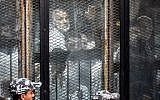 Essam el-Erian (R), one of the highest-ranking leaders of Egypt's banned Muslim Brotherhood, is seen alongside other members of the group inside a glass dock during their trial in the capital Cairo on July 28, 2018. (AFP Photo/Khaled Desouki)