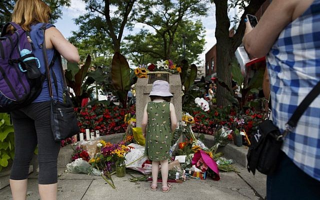 A young girl stands at the foot of a makeshift memorial where people are adding flowers to honor and remember the victims of Sunday night's mass shooting on July 24, 2018 in Toronto, Canada. (Cole Burston/Getty Images/AFP) A young girl stands at the foot of a makeshift memorial where people are adding flowers to honor and remember the victims of Sunday night's mass shooting on July 24, 2018 in Toronto, Canada. (Cole Burston/Getty Images/AFP)