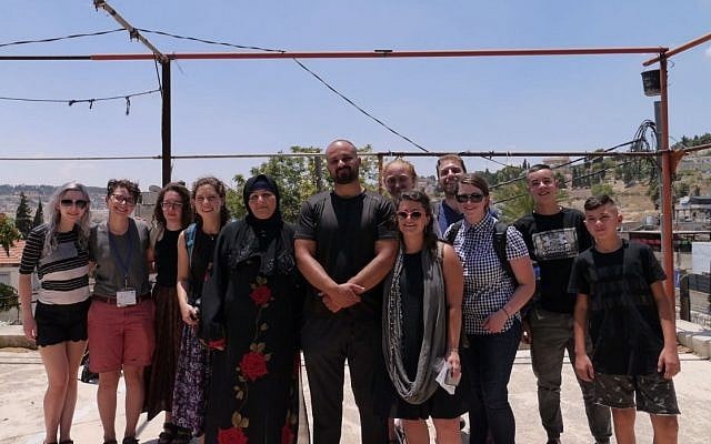 Left-wing activists who staged a walkout from their Birthright trip pose for a photo with members of the Sumarin family, who are facing eviction from their home in East Jerusalem on July 15, 2018. (Courtesy) Left-wing activists who staged a walkout from their Birthright trip pose for a photo with members of the Sumarin family, who are facing eviction from their home in East Jerusalem on July 15, 2018. (Courtesy)