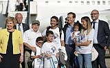 Outgoing Jewish Agency head Nathan Sharansky (3rd left) and new chief Isaac Herzog (4th right) welcome new immigrants on a special 'aliyah' flight organized by the Jewish Agency, at Ben Gurion Airport on July 23, 2018. (Jewish Agency Facebook page/Dudi Salem, Zoog Productions)