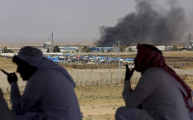Jordanian residents of Jabir village watch aid deliveries to Syrians fleeing government offensive in the south as smoke from unknown fire rises, July 3, 2018. (AP Photo/Raad Adayleh) Jordanian residents of Jabir village watch aid deliveries to Syrians fleeing government offensive in the south as smoke from unknown fire rises, July 3, 2018. (AP Photo/Raad Adayleh)