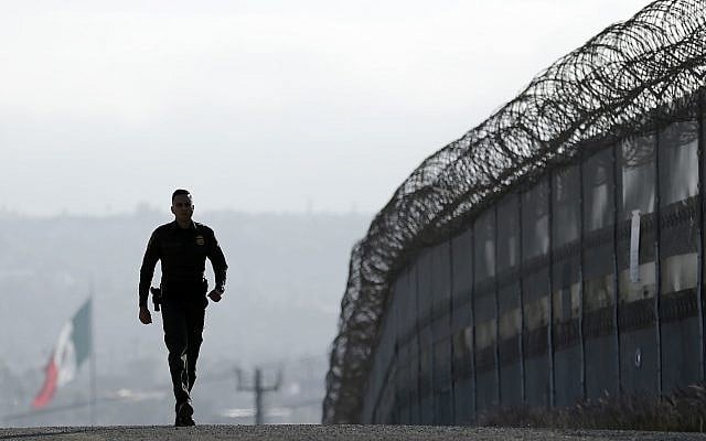 In this June 22, 2016, file photo, Border Patrol agent Eduardo Olmos walks near the secondary fence separating Tijuana, Mexico, background, and San Diego in San Diego (AP Photo/Gregory Bull, File) In this June 22, 2016, file photo, Border Patrol agent Eduardo Olmos walks near the secondary fence separating Tijuana, Mexico, background, and San Diego in San Diego (AP Photo/Gregory Bull, File)
