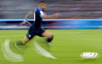 In this photo taken with slow shutter speed France's Kylian Mbappe runs with the ball during the semifinal match between France and Belgium at the 2018 soccer World Cup in the St. Petersburg Stadium, in St. Petersburg, Russia on July 10, 2018. (AP Photo/Petr David Josek)