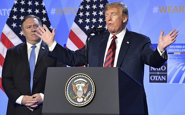 US President Donald Trump raises his hands as US Secretary of State Mike Pompeo, left background, listens during a press conference after a summit of heads of state and government at NATO headquarters in Brussels, Belgium, July 12, 2018. (Geert Vanden Wijngaert/AP) US President Donald Trump raises his hands as US Secretary of State Mike Pompeo, left background, listens during a press conference after a summit of heads of state and government at NATO headquarters in Brussels, Belgium, July 12, 2018. (Geert Vanden Wijngaert/AP)