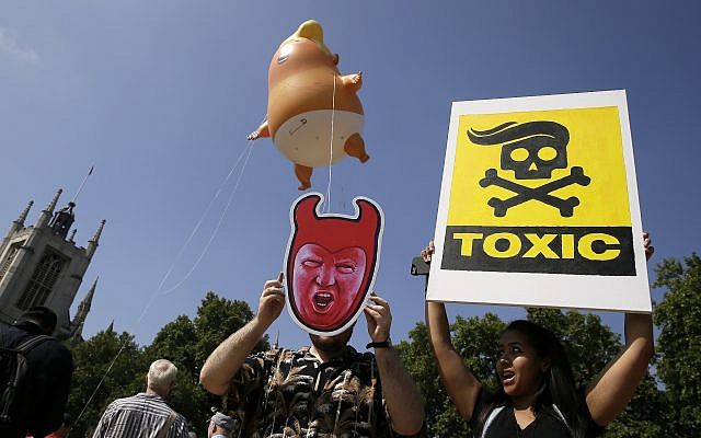 Protestors hold up banners as a six-meter high cartoon baby blimp of US President Donald Trump is flown as a protest against his visit, in Parliament Square in London, England, Friday, July 13, 2018. (AP Photo/Tim Ireland) Protestors hold up banners as a six-meter high cartoon baby blimp of US President Donald Trump is flown as a protest against his visit, in Parliament Square in London, England, Friday, July 13, 2018. (AP Photo/Tim Ireland)