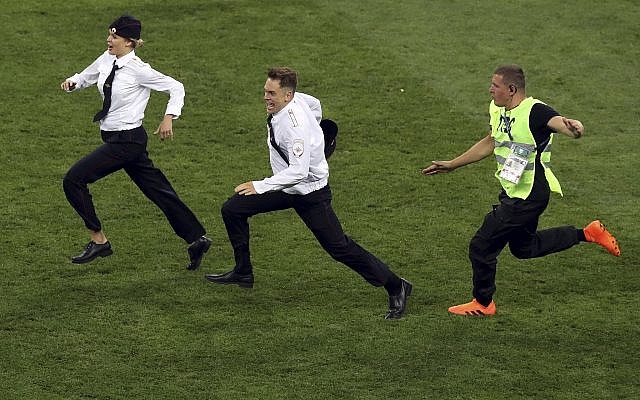 A steward runs after two members of Pussy Riot who invaded the pitch during the final match between France and Croatia at the 2018 soccer World Cup in the Luzhniki Stadium in Moscow, Russia, July 15, 2018. (AP Photo/Thanassis Stavrakis) A steward runs after two members of Pussy Riot who invaded the pitch during the final match between France and Croatia at the 2018 soccer World Cup in the Luzhniki Stadium in Moscow, Russia, July 15, 2018. (AP Photo/Thanassis Stavrakis)