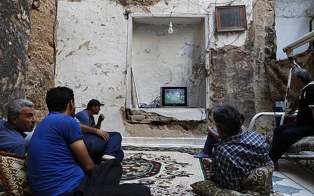 Syrians watch the World Cup soccer final match between France and Croatia at their home, that was partially destroyed by the war leaving two of its rooms without a ceiling, in the town of Ain Terma, in the Eastern Ghouta suburb of Damascus, Syria, July 15, 2018. (AP Photo/Hassan Ammar) Syrians watch the World Cup soccer final match between France and Croatia at their home, that was partially destroyed by the war leaving two of its rooms without a ceiling, in the town of Ain Terma, in the Eastern Ghouta suburb of Damascus, Syria, July 15, 2018. (AP Photo/Hassan Ammar)