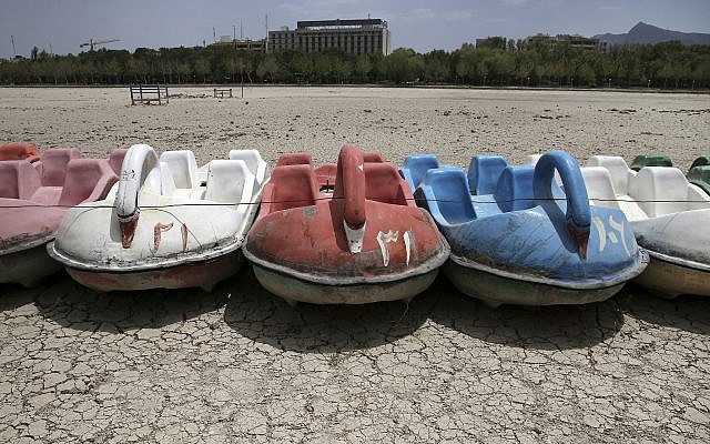 In this Tuesday, July 10, 2018 photo, paddle boats sit on the parched Zayandeh Roud riverbed, in Isfahan, Iran. (AP Photo/Vahid Salemi)