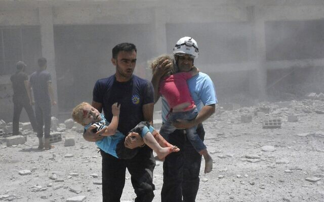 Civil defense workers known as the White Helmets carry children after airstrikes hit a school housing a number of displaced people, in the western part of the southern Daraa province of Syria, on June 14, 2017. (Syrian Civil Defense White Helmets via AP) Civil defense workers known as the White Helmets carry children after airstrikes hit a school housing a number of displaced people, in the western part of the southern Daraa province of Syria, on June 14, 2017. (Syrian Civil Defense White Helmets via AP)