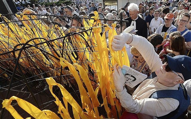 Participants place yellow ribbons with Jewish names on a barbed wire fence during a march that marks 76 years since first deportations from the Warsaw Ghetto and honors Jewish activist Szmul Zygielbojm, who committed suicide in 1943 in protest against the world's indifference to Holocaust, at Umschagplatz Monument in Warsaw, Poland, Sunday, July 22, 2018.(AP Photo/Czarek Sokolowski) Participants place yellow ribbons with Jewish names on a barbed wire fence during a march that marks 76 years since first deportations from the Warsaw Ghetto and honors Jewish activist Szmul Zygielbojm, who committed suicide in 1943 in protest against the world's indifference to Holocaust, at Umschagplatz Monument in Warsaw, Poland, Sunday, July 22, 2018.(AP Photo/Czarek Sokolowski)